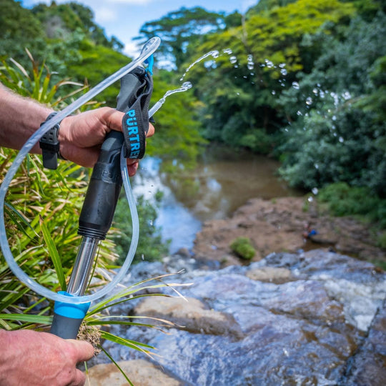 Hiker pumping water with PÜRTREK trekking pole filtration system